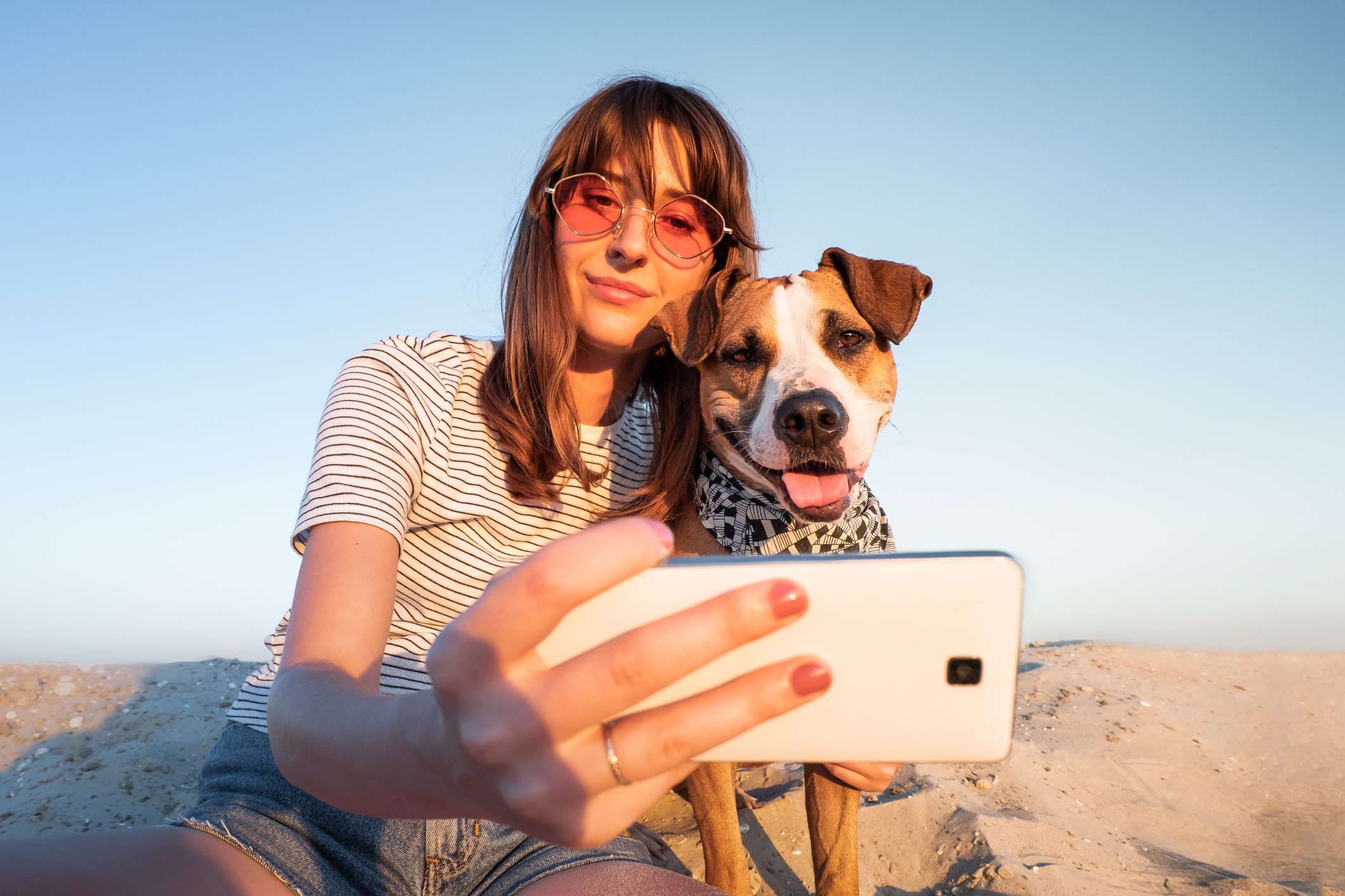 Student pet caregiver taking a selfie with a dog